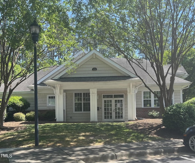 view of front of home with a front yard and french doors