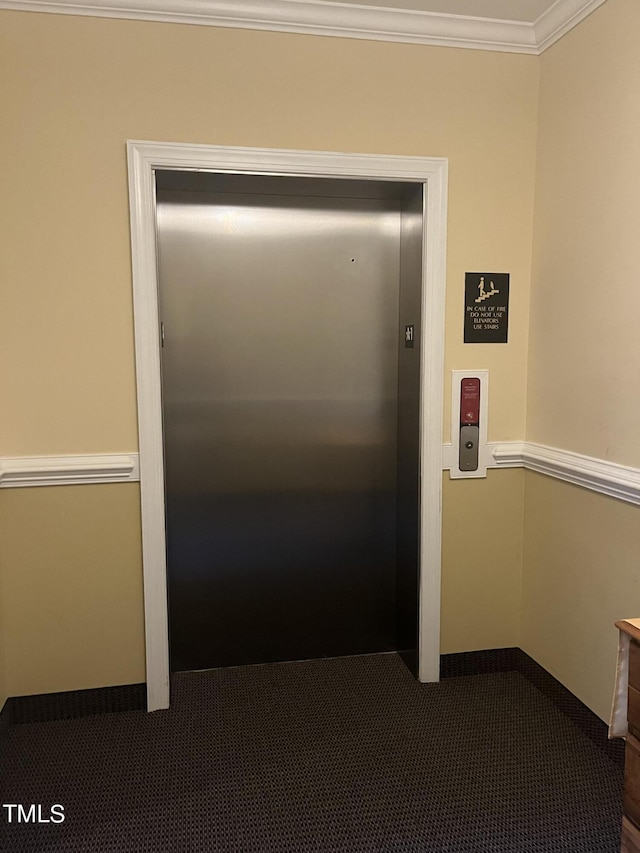 hallway featuring carpet, elevator, and ornamental molding