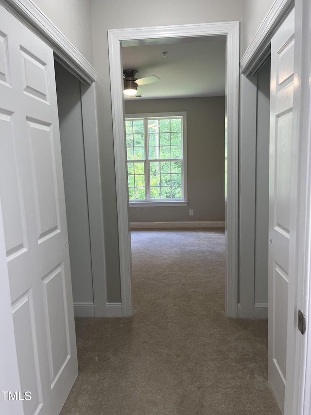 hall with dark colored carpet