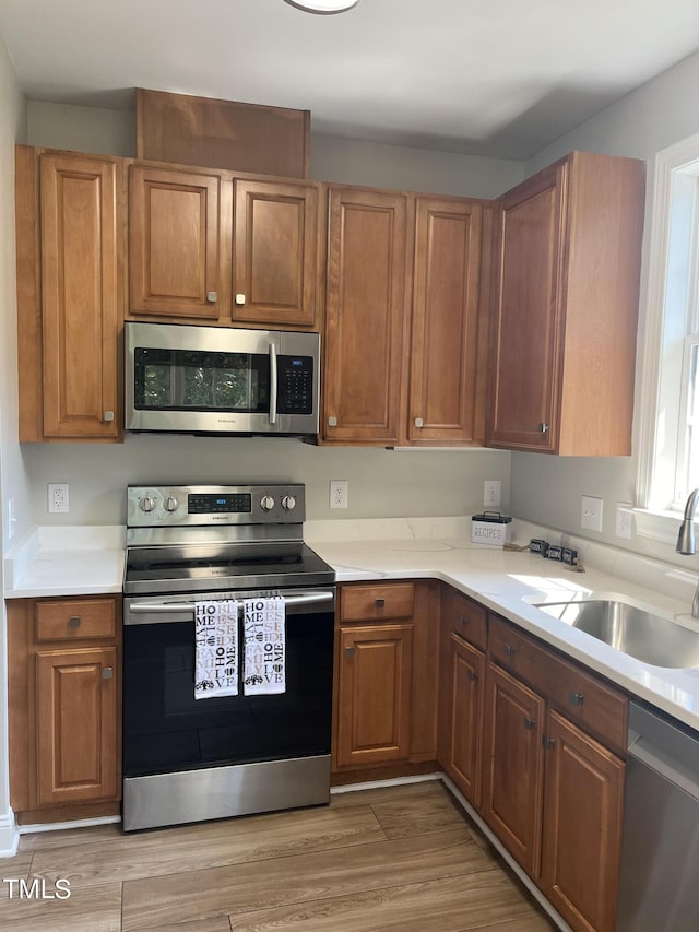 kitchen featuring sink, light hardwood / wood-style floors, and appliances with stainless steel finishes