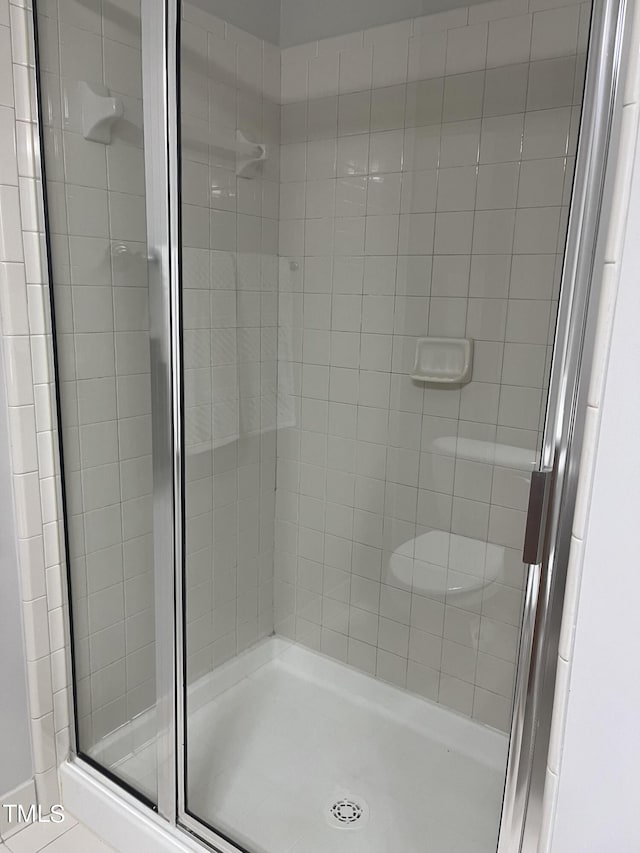 bathroom featuring tile patterned floors and a shower with door