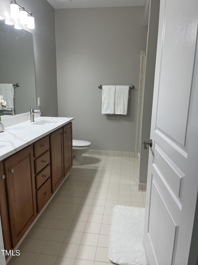 bathroom featuring tile patterned floors, vanity, toilet, and a notable chandelier