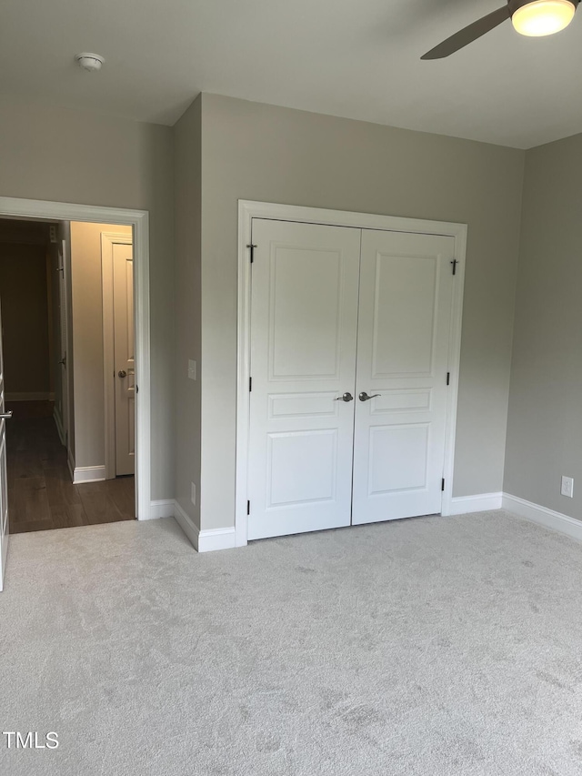 unfurnished bedroom featuring carpet floors, a closet, and ceiling fan