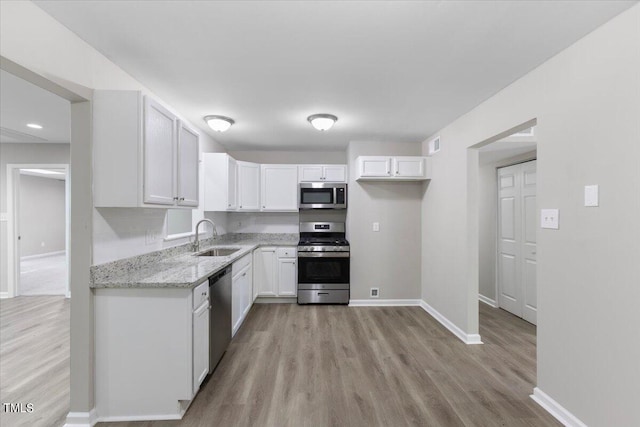 kitchen featuring white cabinets, light hardwood / wood-style flooring, appliances with stainless steel finishes, and sink