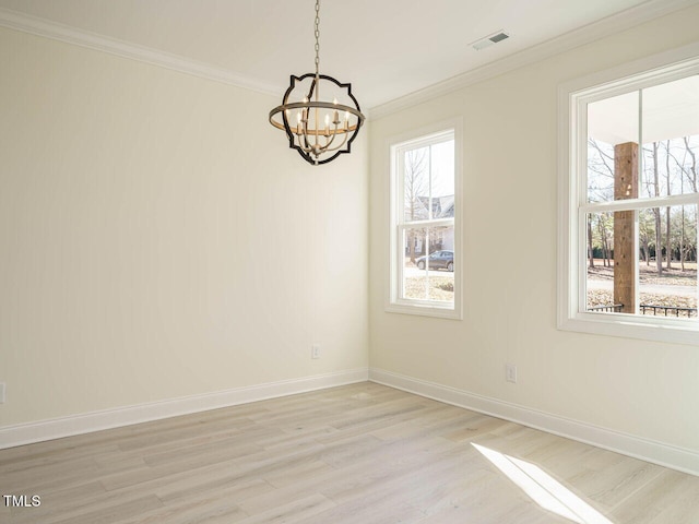 empty room with light hardwood / wood-style floors, crown molding, and a chandelier