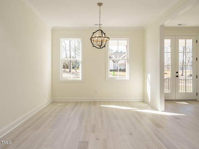 unfurnished dining area featuring a chandelier, french doors, crown molding, and light hardwood / wood-style floors