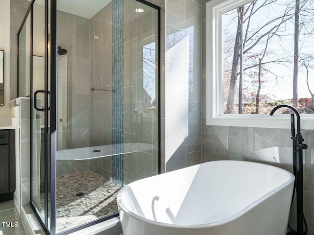 bathroom featuring tile walls and plus walk in shower