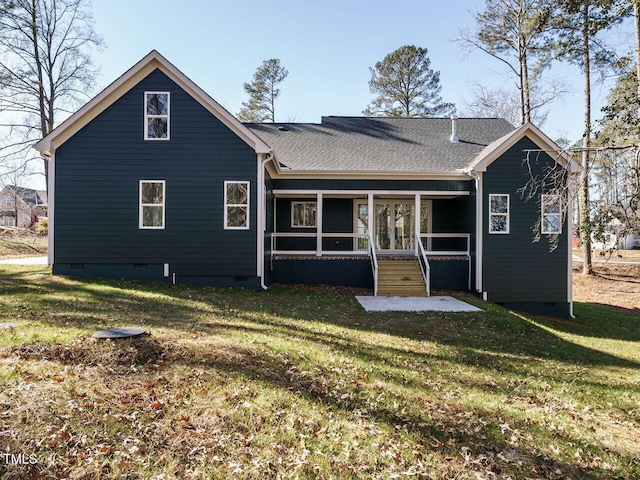 rear view of house with a yard and a sunroom