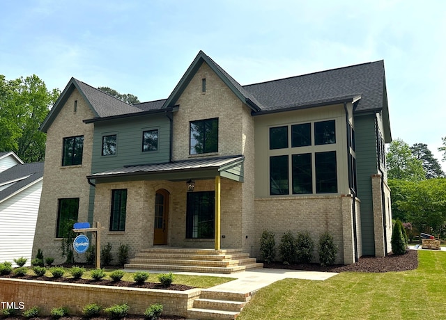 view of front of house featuring a front lawn, brick siding, a porch, and roof with shingles