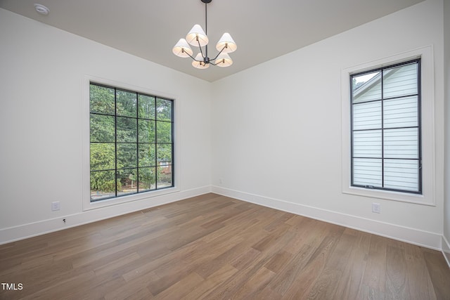 1000 Marilyn Dr, Raleigh, NC 27607 - unfurnished room with a chandelier, wood finished floors, baseboards, and plenty of natural light