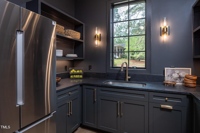1000 Marilyn Dr, Raleigh, NC 27607 - kitchen with freestanding refrigerator, a sink, open shelves, dark stone countertops, and gray cabinetry