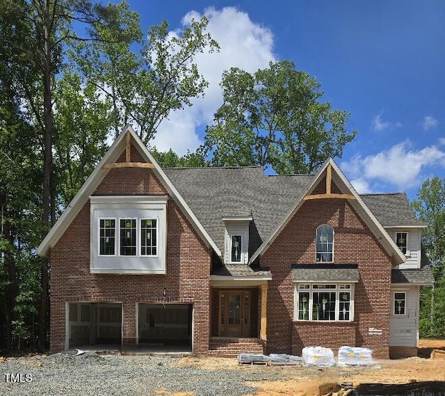 view of front facade featuring a garage, brick siding, and roof with shingles