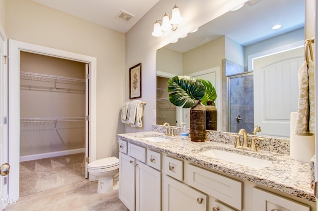 bathroom with a shower stall, a walk in closet, a sink, and double vanity