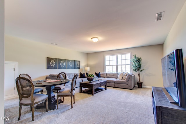 living room with baseboards, visible vents, and light carpet