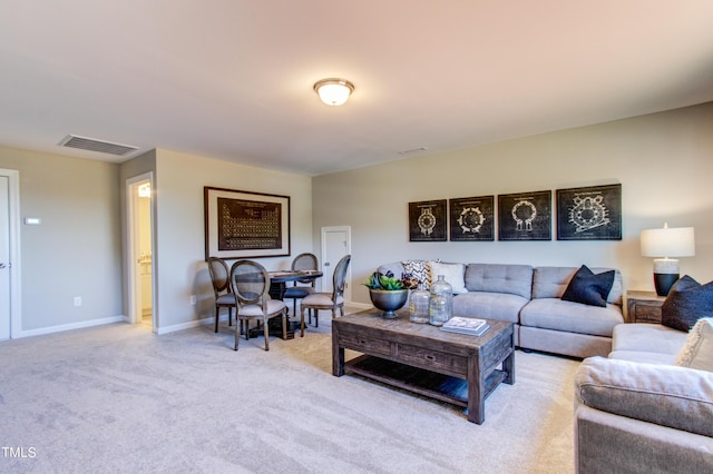 living room with baseboards, visible vents, and light carpet