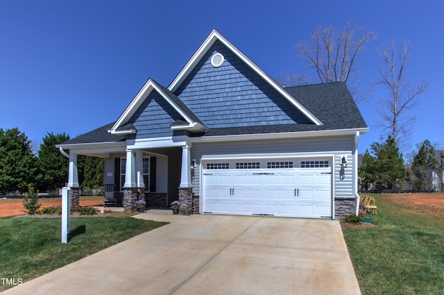 craftsman inspired home featuring an attached garage, a porch, stone siding, concrete driveway, and a front yard