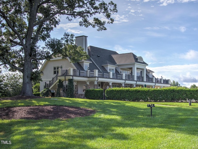 exterior space featuring a lawn, stairway, stone siding, and a chimney