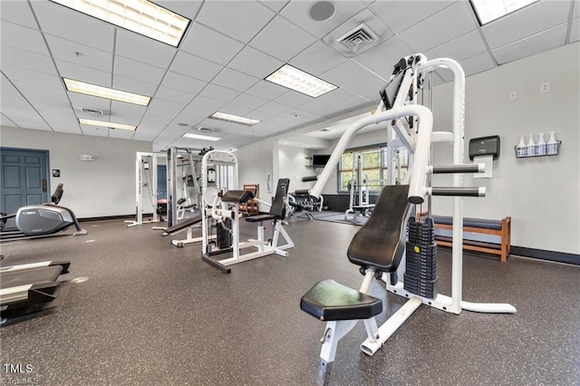 exercise room with visible vents, baseboards, and a drop ceiling