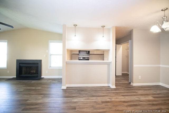 kitchen featuring decorative light fixtures, stainless steel appliances, and dark wood-type flooring