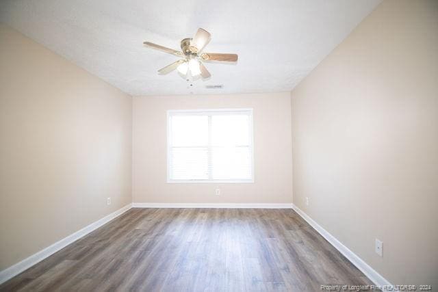 empty room featuring ceiling fan and dark wood-type flooring