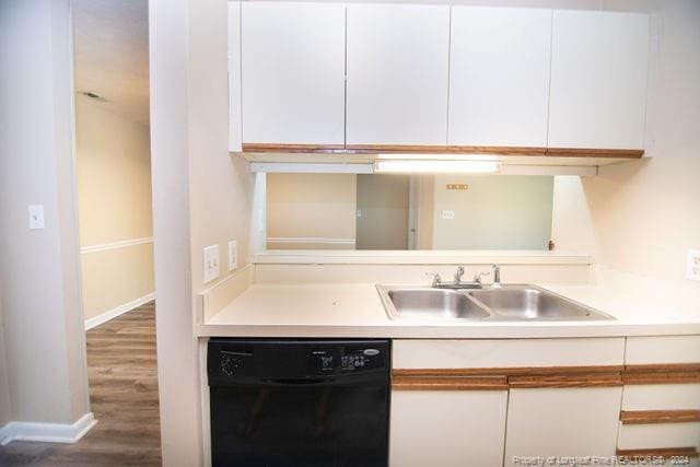 kitchen featuring dark hardwood / wood-style flooring, dishwasher, white cabinets, and sink