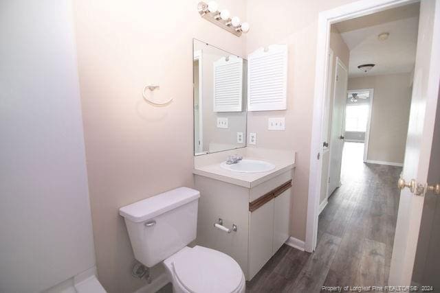 bathroom featuring vanity, wood-type flooring, and toilet