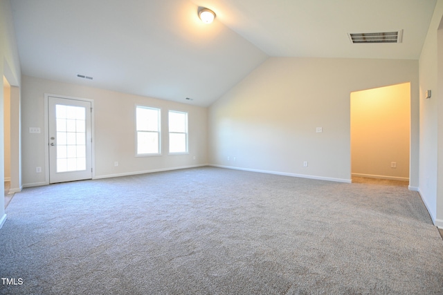 carpeted spare room with vaulted ceiling