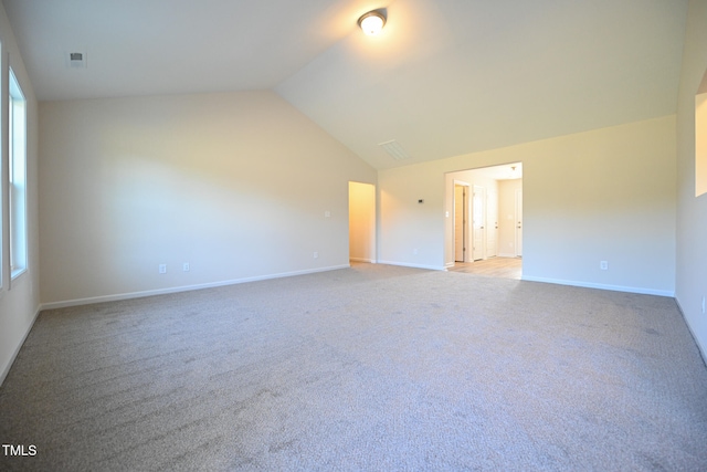 spare room with carpet and high vaulted ceiling