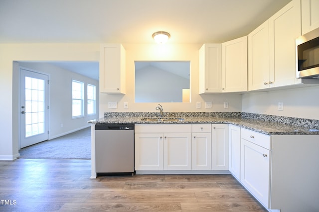 kitchen with stone counters, white cabinetry, appliances with stainless steel finishes, and sink