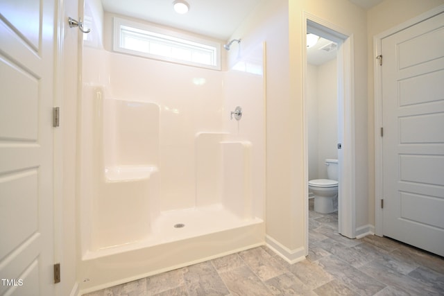 bathroom with toilet and walk in shower