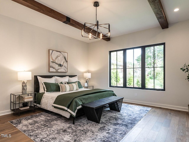 bedroom with beamed ceiling, dark hardwood / wood-style flooring, and an inviting chandelier