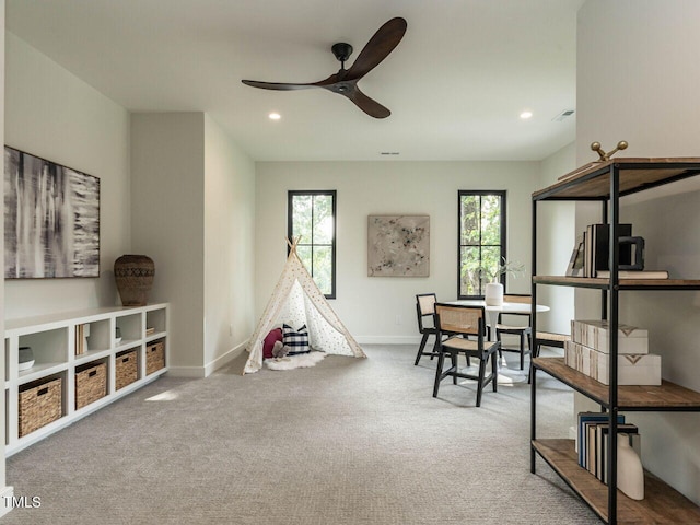 recreation room featuring carpet flooring, ceiling fan, and a healthy amount of sunlight