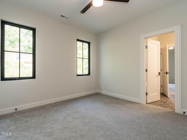 spare room featuring light colored carpet and ceiling fan