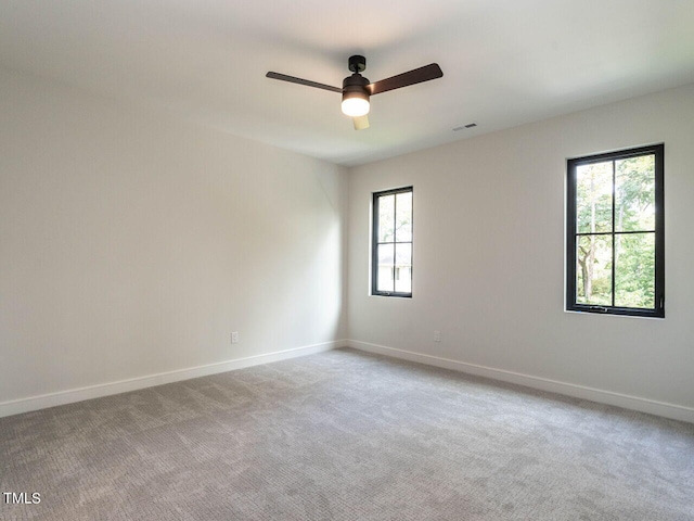 empty room featuring ceiling fan and light colored carpet