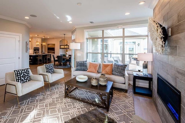 living room featuring hardwood / wood-style flooring, ornamental molding, and a fireplace