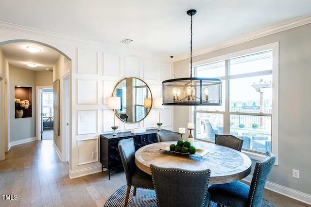 dining area featuring wood-type flooring and ornamental molding