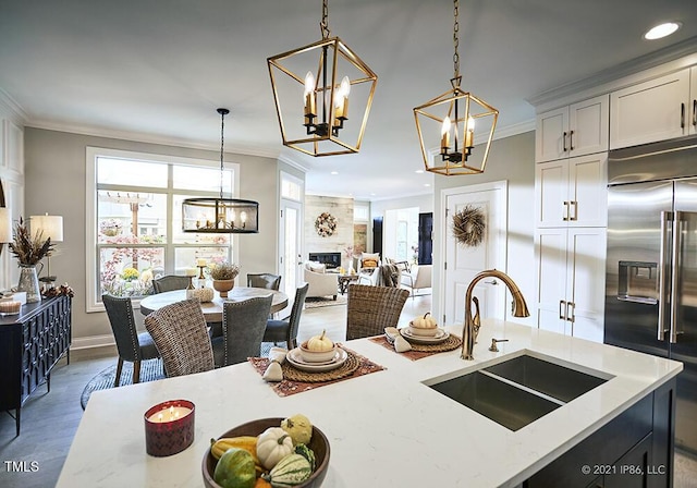 1005 Bridgeforth Ln, Durham, NC 27713 - kitchen featuring a chandelier, built in refrigerator, a sink, ornamental molding, and pendant lighting