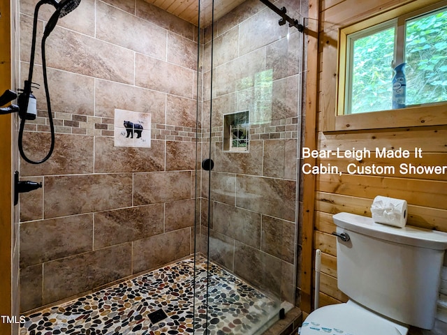 bathroom featuring tiled shower and toilet