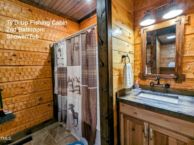 bathroom featuring wooden ceiling, tile floors, vanity, and wood walls