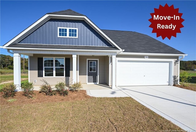 view of front of property with a garage, covered porch, and a front lawn