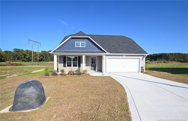 view of front facade with covered porch, a garage, and a front lawn