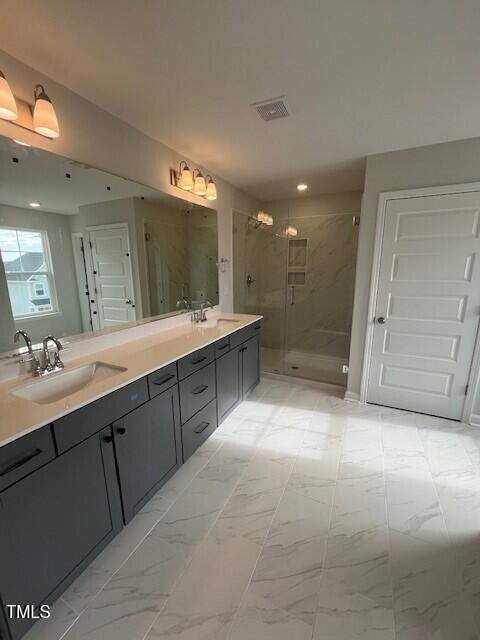 bathroom with vanity and a shower with door