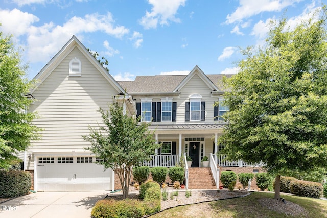 1329 Endgame Ct, Wake Forest, NC 27587 - view of front of home with covered porch, an attached garage, a standing seam roof, concrete driveway, and metal roof