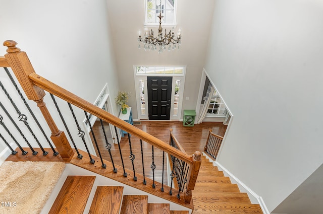 foyer featuring wood-type flooring, a high ceiling, and a chandelier