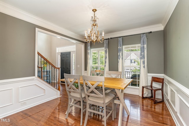 dining area featuring an inviting chandelier, ornamental molding, and hardwood / wood-style flooring