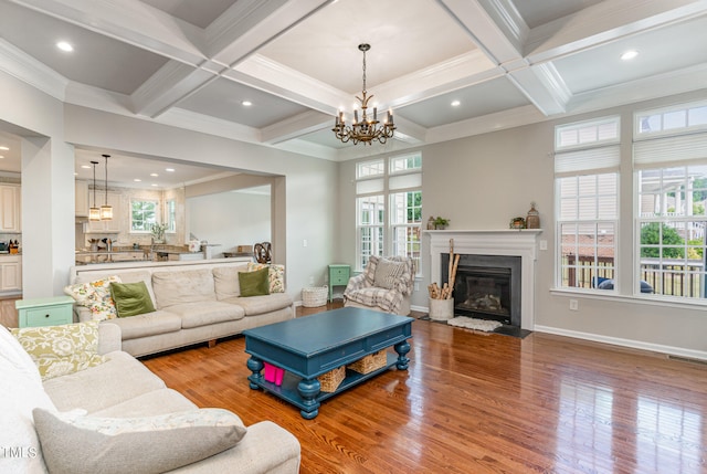 living room with hardwood / wood-style floors, coffered ceiling, and crown molding