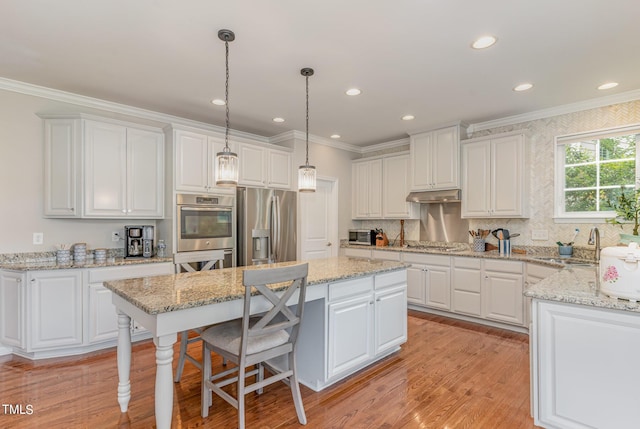 1329 Endgame Ct, Wake Forest, NC 27587 - kitchen with stainless steel appliances, crown molding, a center island, white cabinets, and a breakfast bar