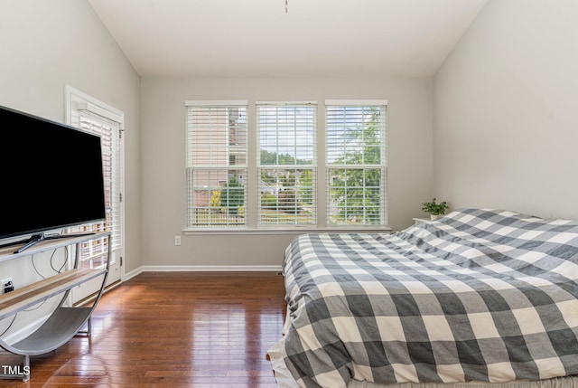 bedroom with dark hardwood / wood-style flooring and lofted ceiling