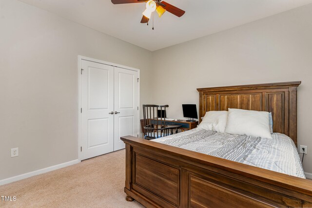 bedroom featuring light colored carpet, a closet, and ceiling fan