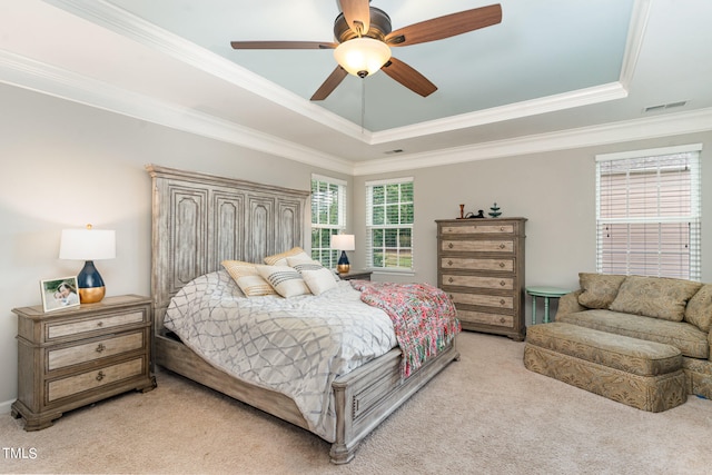 bedroom with ceiling fan, ornamental molding, a tray ceiling, and carpet floors